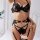 Woman wearing black lace garter belt set with gold chains, featuring sexy shapewear and stocking holders in style erotic li...