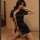 Woman modeling black satin retro chinese qipao lingerie set with split hem and traditional frog closures on bed.