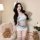 Woman wearing romantic airline-style sexy bodysuit with shoulder-baring flight attendant dress for date night, posing in cozy...