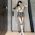 A woman poses in a romantic school uniform-inspired outfit featuring a backless jumpsuit with a bow tie, knee-high socks, and...