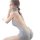 Woman wearing romantic sheer lace lingerie set with open-front backless knit sweater and mini skirt sleepwear outfit.