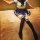 A person wearing a sailor-style school uniform with a white top, navy skirt, and thigh-high stockings sits on a carpeted floo...