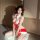 A woman poses in a festive red and white christmas-themed nightgown, featuring playful bows and a cute design, perfect for ho...