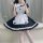 A woman poses wearing a s5xl japanese maid dress, featuring a black and white design with ruffles and a heart emblem, perfect...