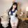 Woman modeling white sailor uniform lingerie set with blue bow, sheer cutouts, thigh highs, and bear ears headband.