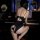 Woman in black lingerie with heart cutout, seated at piano.
