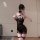 Woman wearing black lace halter lingerie set with sheer bodycon dress and fishnet stockings, capturing a mirror selfie.