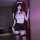 A woman poses confidently wearing a white halter top with black accents, paired with a black mini skirt and thigh-high stocki...