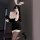 Woman in black secretary bunny girl lingerie set with white lace trim, gloves, and ears, posing seductively for role play.