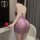 Woman wearing purple lace cheongsam nightgown with deep v and transparent straps, holding red rose.