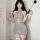 Woman wearing gray seductive knit sweater with open-chest lace-up design, high-neck bodysuit style for date night.