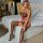 Woman wearing seductive lace bikini set with garter belt, featuring fishnet stockings and red trim, posed elegantly on a bed ...