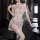 Woman modeling a sheer white lace bodysuit with floral embroidery, open-crotch design, and matching garter straps for boudoir...