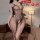 Woman wearing a seductive lace bodysuit with mesh detailing, posing in a cozy bedroom setting. perfect for romantic sleepwear...