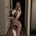 Woman in black lace lingerie set with garter belt, posing seductively in mirror selfie — pure temptation sleepwear for women.