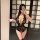 Woman modeling black lace lingerie set with sheer panels, removable cups and garter stockings in mirror selfie.