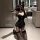 Woman kneeling in black lace lingerie set with sheer mesh bodysuit, garter stockings, and cat ears.