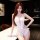 Woman in white lace lingerie set with deep v-neck and sheer panels, posing seductively on marble counter.