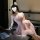Woman in pink seductive lace mesh slip dress set posing elegantly at a table with wine glass and laptop.
