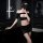 Woman in black seductive lace peek-a-boo two-piece sleepwear set with low-cut bra and matching shorts, posing in modern bathr...