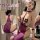 Woman modeling purple sheer chemise with hook-neck, back cutouts, and lace details in bedroom setting.
