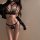 Woman modeling black lace tie-back bikini set with gold chains, sheer cups, and strappy design—seductive lace tie-back bikini...