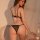 Woman wearing seductive leopard print lace thong set with adjustable straps, showcasing sheer bedroom lingerie design.