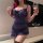 Woman wearing a seductive navy blue lace lingerie set with ruffled hem, holding a wine glass.
