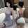 Woman wearing a silver glittery seductive maid costume lingerie set with lace detailing, featuring a no-remove design for mod...