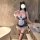 Woman wearing seductive maid costume set with lace trim, tulle dress, apron, and cat ear headband in modern bathroom.