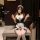 Woman in seductive maid costume sleepwear set with white apron, black dress, and thigh-high stockings.