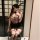 Woman in a seductive ol secretary outfit with a bodycon skirt and floral top, posing with bunny ears.
