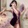 Woman wearing seductive purple cheongsam lingerie set with open back, holding fan, in cozy bedroom setting.