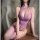 Woman wearing a seductive purple fishnet bodystocking with sheer mesh, halter neck, and open sides.