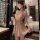 Woman in a seductive qipao lingerie set, featuring silk sleepwear with floral embroidery, holding a fan in a romantic setting...