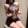 Woman wearing a black lace seductive secretarial lingerie set, featuring a halter neck design and sheer mesh shorts.