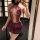 Woman in purple lace lingerie set with sheer bodice and mini skirt, taking mirror selfie.