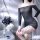 Woman wearing a black off-shoulder mini dress with fishnet stockings, posing elegantly beside a decorative table with flowers...