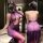 Woman wearing a sheer purple lace lingerie dress with side slit, featuring a halter neck and backless design.