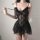 Woman wearing a black sheer lace camisole and backless slip dress, featuring floral details and a flirty skirt.