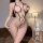 Woman modeling a black sheer open-crotch bodysuit with lace mesh detailing and backless design, highlighting curves in a diml...