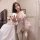 Woman wearing a seductive sheer princess sleep dress with transparent lace, backless design, and chest and hip reveal details...