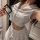 Woman wearing white sailor-style lingerie set with crop top and pleated skirt, holding id badge — playful yet modest sleepwea...