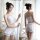 Woman modeling white lace bodysuit and backless camisole set, elegant sleepwear ensemble with ruffled shorts for sophisticate...