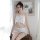 Woman wearing white lace bodysuit and backless camisole set, elegant sleepwear ensemble with delicate detailing.