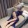 Woman lounging on sofa in blue lace lingerie set with feather mask, featuring delicate straps and elegant nightwear design.