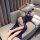 Woman in blue lace lingerie set with feather mask, lounging on sofa—modest yet seductive nightwear.