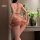 Woman wearing a sensual backless cheongsam dress, featuring a slim-fit design with butterfly patterns, perfect for provocativ...