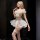 Blonde woman wearing white lace sensual bridal lingerie set with off-shoulder top, ruffled skirt, fishnet stockings, and flor...