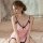 A woman sits on a bed wearing a sensual lace bodycon slip dress, featuring delicate black lace trim and a bow detail at the n...